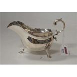 A Walker & Hall silver sauceboat, in the George II style, having flying S-scroll handle and on
