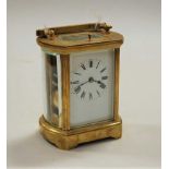 A lacquered brass cased carriage clock, of barrel shape, having enamelled dial with Roman