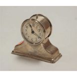 A late Victorian silver cased miniature mantel clock, having a silvered dial with Arabic numerals,