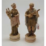 A pair of Royal Dux type porcelain musician figures, each heightened with gilt enamels and on