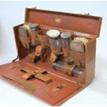 An early 20th century gent's fitted travelling vanity case, having various silver topped glass