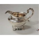 An early Victorian silver cream jug, having gilt washed bowl and on scroll feet, 5.3oz, London 1837,