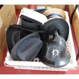 A box of miscellaneous hats, to include mortar board, fireman;s helmet and military side caps