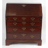 A George III mahogany slopefront writing bureau, having a fitted interior over four long graduated