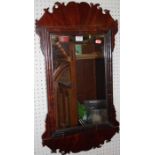 A 19th century mahogany Chippendale style fret carved rectangular wall mirror, having a cushioned