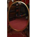 A contemporary gilt metal ropetwist decorated oval hanging wall mirror, having twin lower candle