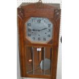 A 1930s oak droptrunk wall clock, having a striking and chiming movement, with pendulum, h.65cm