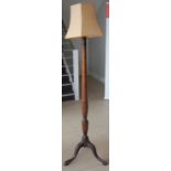 A mahogany standard lamp, raised on floral carved supports, with shade, overall h.185cm