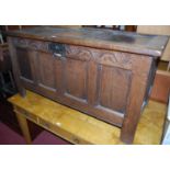 An early 18th century joined oak three panelled hinge topped coffer, having a floral arch relief