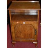 A 1930s figured walnut ledgeback single door bedside cupboard, having open upper compartment and