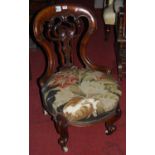 An early Victorian mahogany balloon back and pierced floral carved splatback nursing chair, having