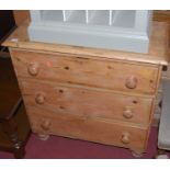 A Victorian pine chest of three long drawers, having turned knob handles and raised on turned