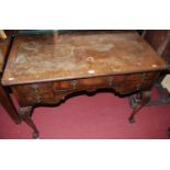 An early 20th century figured walnut and crossbanded five drawer dressing table, raised on shell