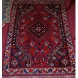 A Persian woollen red ground Shiraz rug, 156 x 114cm