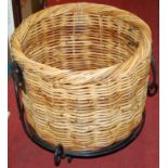 A wicker log basket, on wrought iron stand