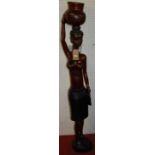 A contemporary African carved hardwood standing figure of a nude female water-carrier, h.168cm