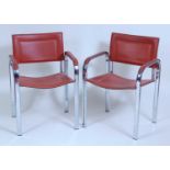 A pair of 1980s flattened tubular chrome framed and tan vinyl pad back and seat slung open elbow