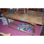 A 19th century oak plank topped refectory dining table, having cleated ends, raised on turned and