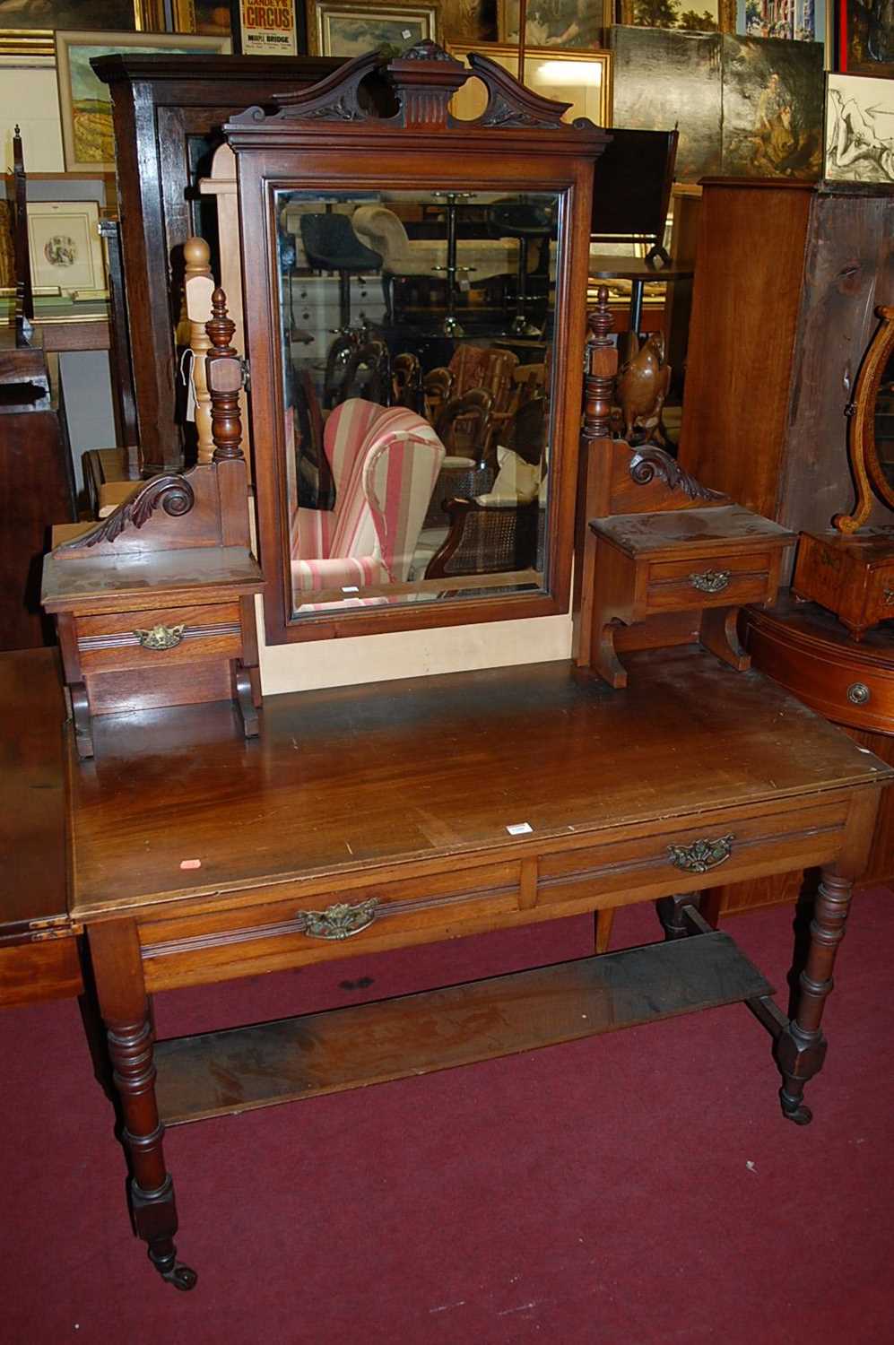 A late Victorian walnut bevelled swing mirrorback dressing table, having twin frieze drawers and