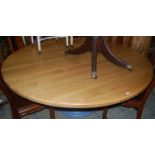 A large contemporary light oak topped circular dining table, raised on blue painted turned