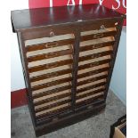An early 20th century oak twin tambour fronted office filing cabinet, each interior housing nine