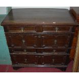 An antique geometric moulded oak chest, of four long drawers, comprised of two sections and having