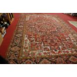 A Persian woollen red ground rug, of good size, having all-over geometric floral decoration within