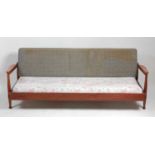 A 1960s Danish teak sofa-bed, having swivel upholstered back rest, with sliding compartment doors,