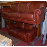 A contemporary tan leather two-piece suite, comprising three-seater and a two-seater sofa, each with