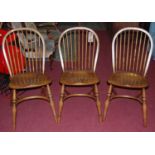 A set of three contemporary elm and ash stickback kitchen chairs, each having a dished seat