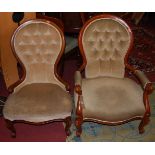 A pair of Victorian style stained walnut framed lady's and gent's buttoned spoonback armchairs, each