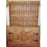 A 19th century rustic nailed and planked pine kitchen dresser, having three-tier open plate rack