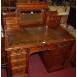 An Edwardian walnut kneehole writing desk, having a raised and mirrored superstructure with twin