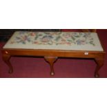 An early 20th century oak and tapestry embroidered double stool, raised on cabriole supports, length