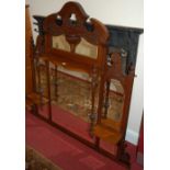 An Edwardian floral relief carved bevelled glass overmantel mirror; together with an ebonised relief