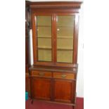A circa 1900 mahogany bookcase cupboard, having twin glazed upper doors over base fitted with twin