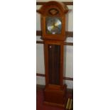 A contemporary hardwood grandmother clock, having silver and brass dial, with three train weight