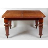 An early Victorian mahogany extending dining table, the wind-out top having a moulded edge and two