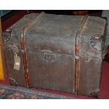 An early 20th century canvas clad, wood, metal and leather bound hinge topped travelling trunk,