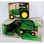 An Ertl John Deere combine and tractor large scale heavy metal group, to include a John Deere