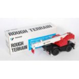 A Made in Japan 1:50 scale model of a Tadano rough-terrain 4-wheel crane, comprising of red, white