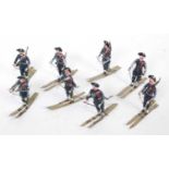 Eight pre-war Heyde French Chasseur Alpine troops on skis, seven with rifles and one officer (all