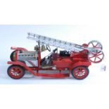 A Mamod live steam fire engine, of usual specification, comprising of red body with red spoked hubs,