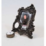 A small brass framed easel mirror, having a bevelled plate within a scrolling floral surround with