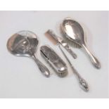 An early 20th century silver backed dressing table set, comprising two brushes, a comb, a mirror,