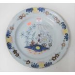 An 18th century Delft charger, the centre typically decorated with flowers within further floral