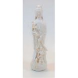 A 20th century blanc-de-chine figure of Guanyin, in typical standing pose, with dragons at her feet,