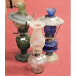 An early 20th century green glass oil lamp; together with one other similar, and a spare shade and