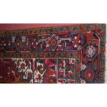 A Persian red ground woollen rug, having an all-over geometric floral trailing ground, 300 x