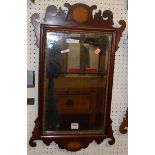 A circa 1900 mahogany Chippendale style fret carved wall mirror with satinwood starburst inlays,